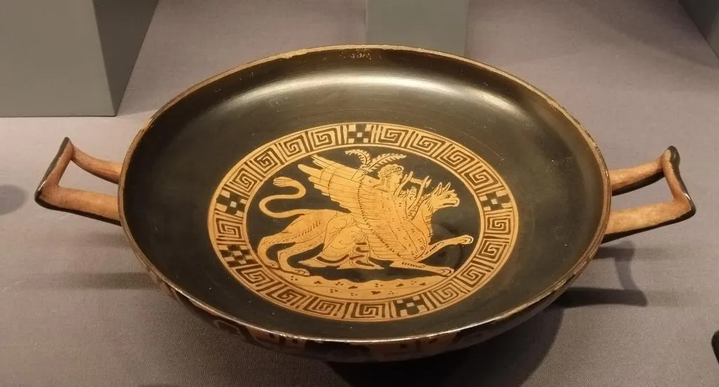 Griechische rotfigurige Kylix mit zwei Henkeln, zeigt Apollon auf einem Greifen, eine Leier spielend, umrahmt von einem Mäandermuster. Attisch, frühes 4. Jahrhundert v. Chr.