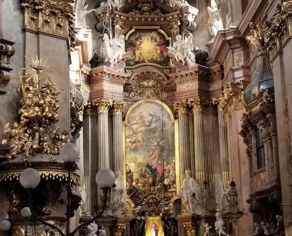 Baroque high altar of Peterskirche in Vienna with gilded sculpture, columns, and religious paintings.