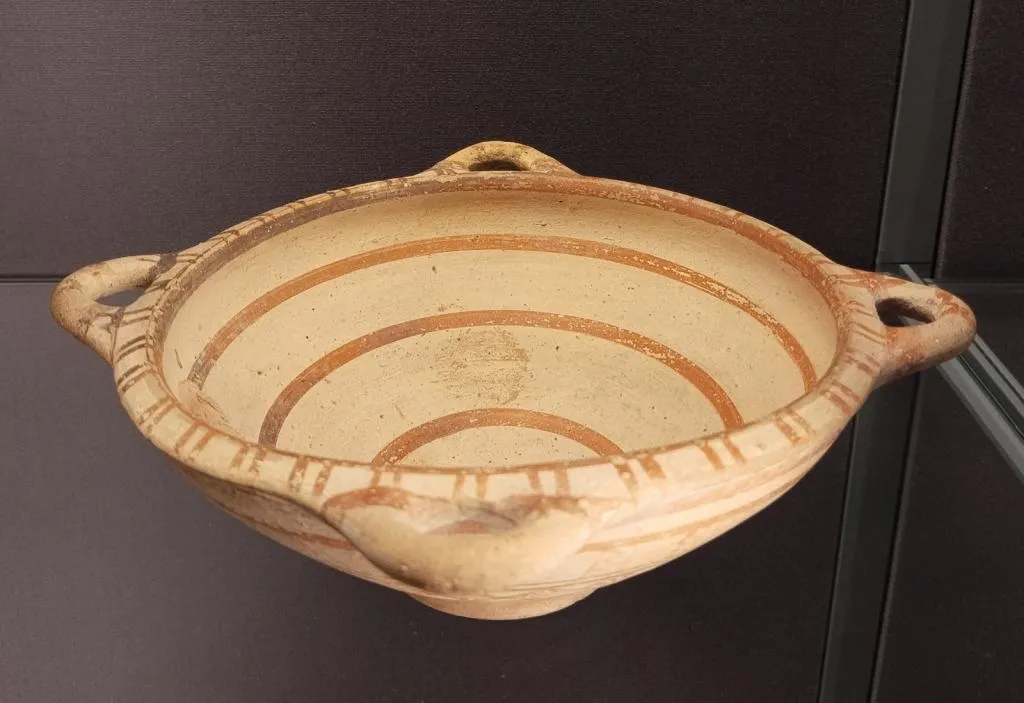 Ancient Boeotian kylix with two handles and painted geometric decoration, including concentric bands and vertical rim lines. Made in the second half of the 6th century BCE.