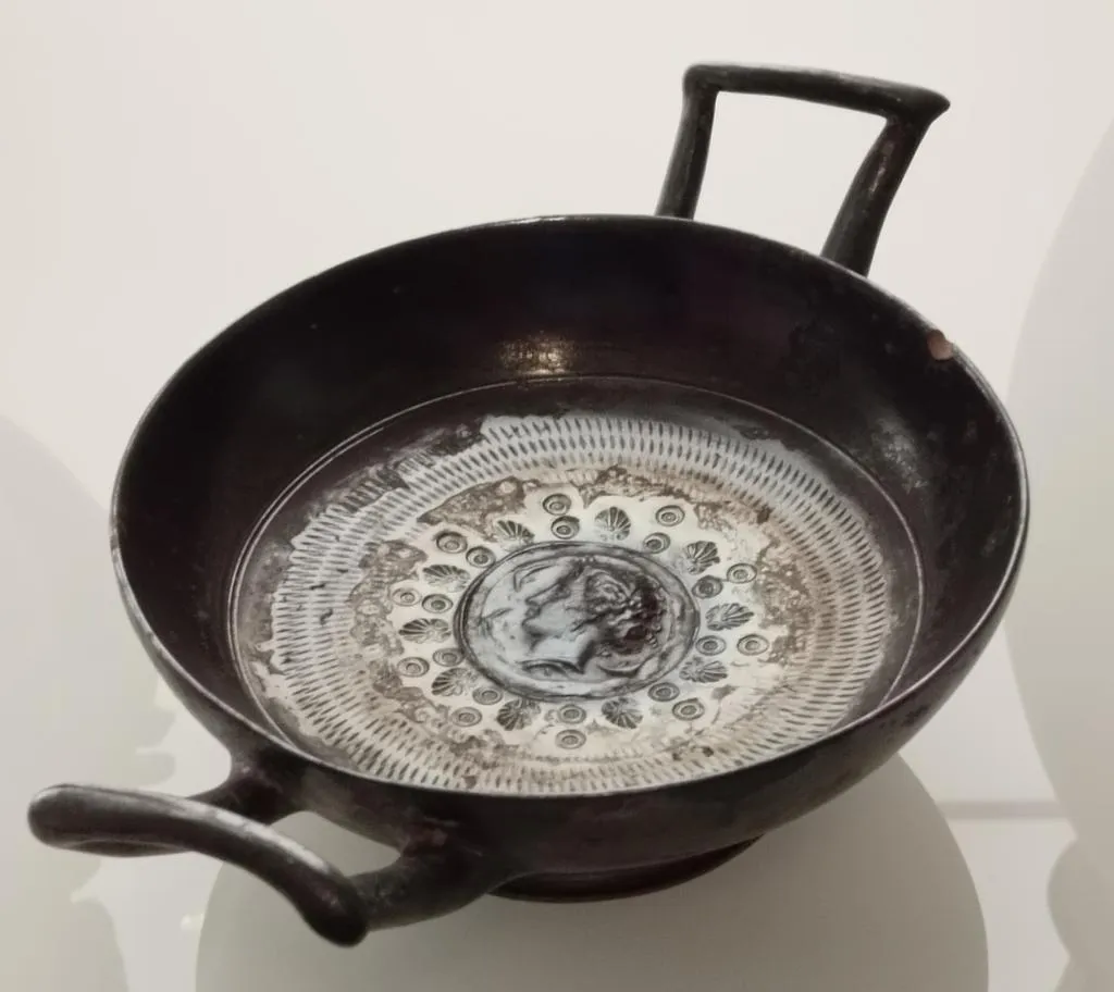 Antike calenische Kylix mit zwei Henkeln, Reliefmedaillon mit dem Kopf der Nymphe Arethusa, umgeben von Muschel- und Palmettenmotiven. Um 300 v. Chr.