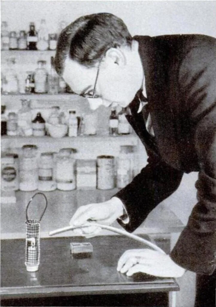 Wissenschaftler demonstriert einen Sicherheitstest an einer Davy-Sicherheitslampe, indem er im Labor einen Gasstrom auf die Flamme richtet.