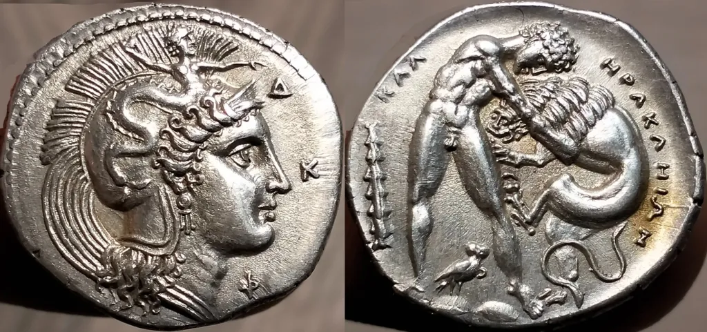 Two-sided image of a modern replica of a silver stater from Herakleia in Lucania. The obverse shows Athena facing right in a crested helmet. The reverse shows Herakles grappling with the Nemean lion, with surrounding inscription and field symbols.