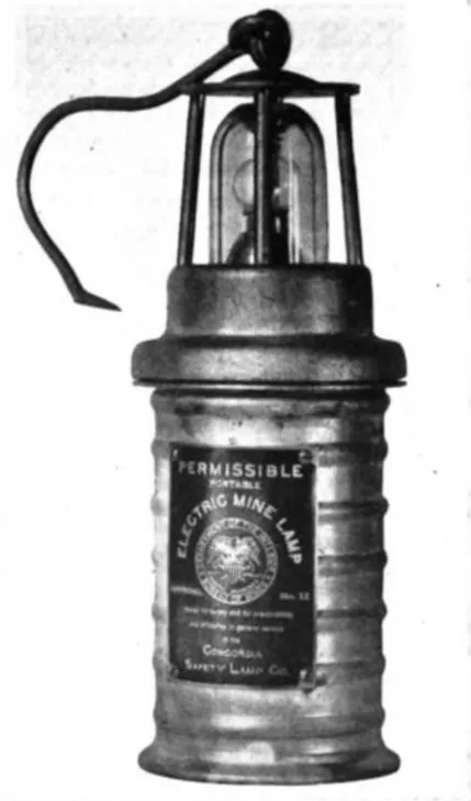 Self-contained electric mine lamp from the 1920s, featuring an integrated battery and protective housing.