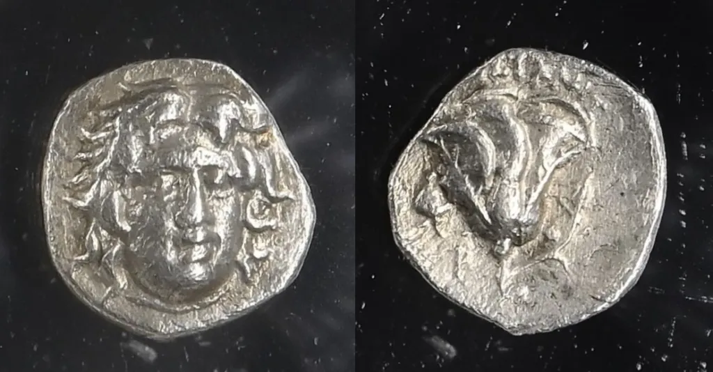 Photograph of a Rhodian silver tetradrachm shown in two views on a dark background, with the facing head of Helios on the obverse and a rose with bud on the reverse.