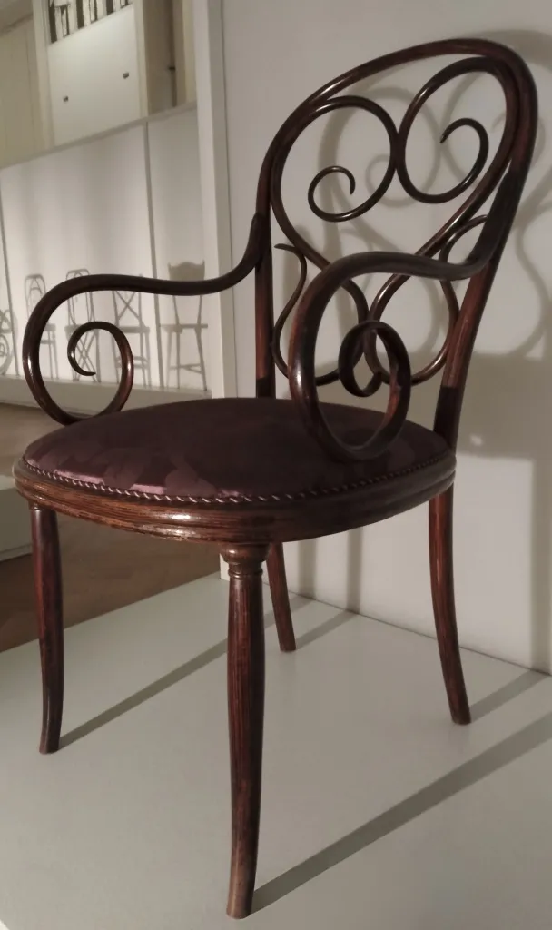 Side view of Thonet armchair model No. 4, with decorative bentwood scrollwork and upholstered seat.