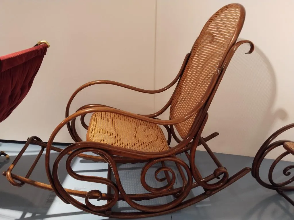Thonet Bugholz-Schaukelstuhl Modell Nr. 7021/B mit elegant geschwungenem Gestell sowie Sitz und Rückenlehne aus Rohrgeflecht, im Museum ausgestellt.