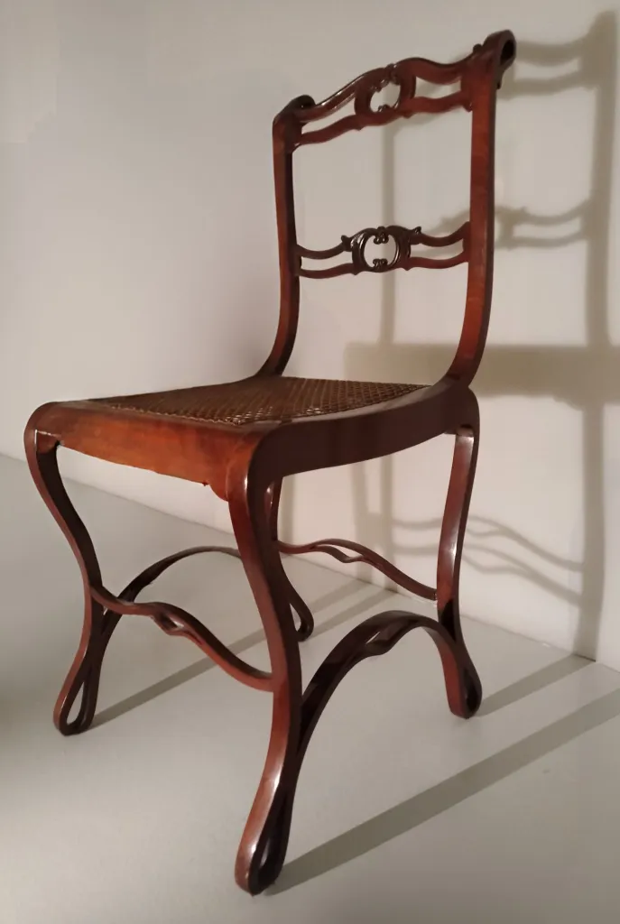 Side view of an early Thonet Boppard chair with curved laminated wood frame and carved double-rail backrest.