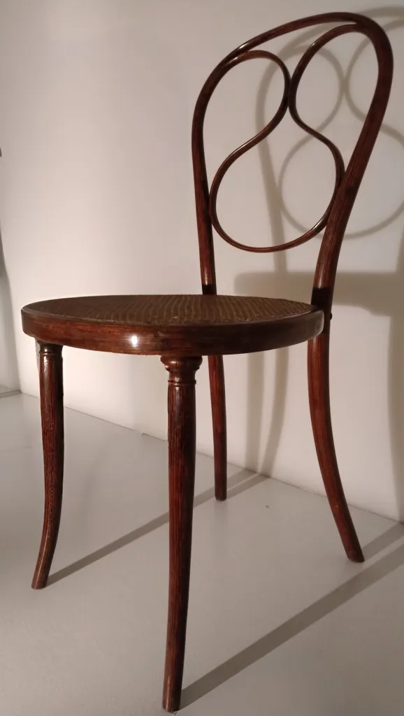 Side view of Thonet chair model No. 1, with a bentwood frame, curved backrest, and cane seat.