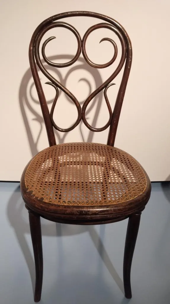 Wooden Thonet bentwood Chair No. 4 with a round cane seat and curved backrest design, produced around 1850 and used in Vienna’s cafés.