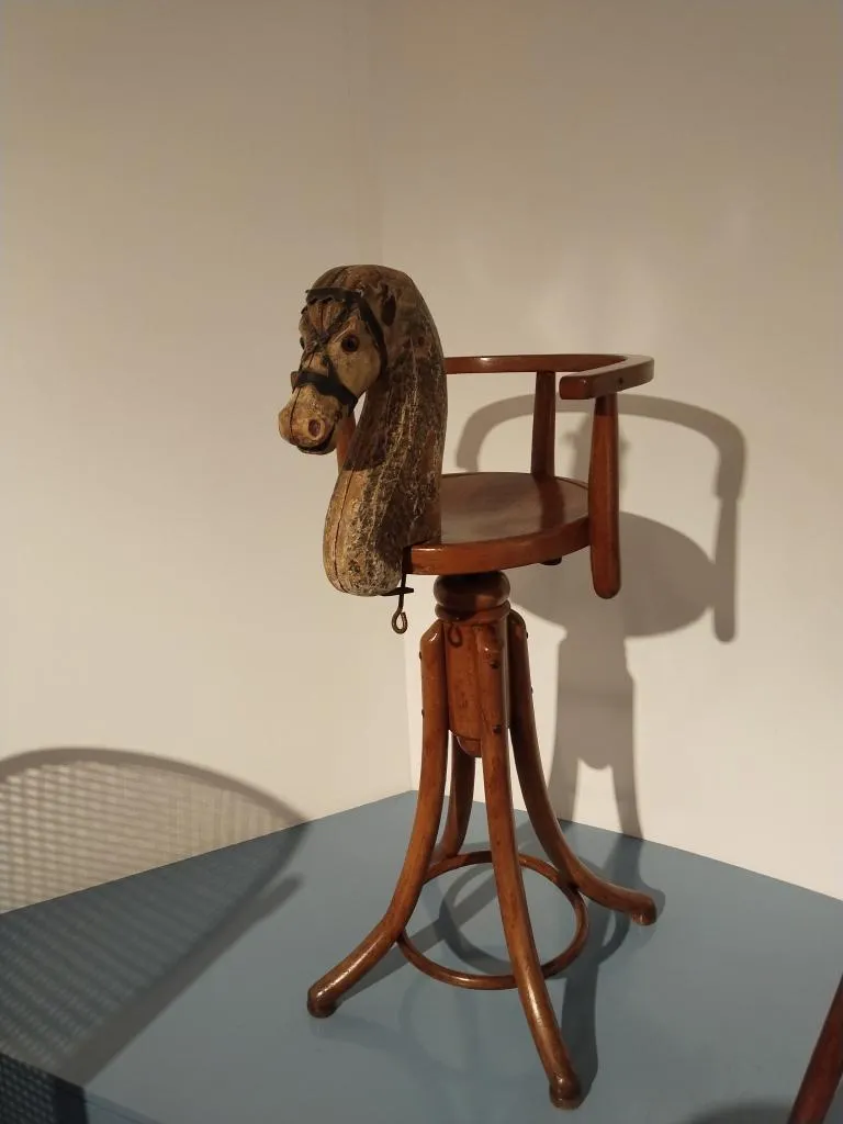 Seitenansicht des Thonet Kinderfriseurstuhls Nr. 649 B mit geschnitztem Pferdekopf.