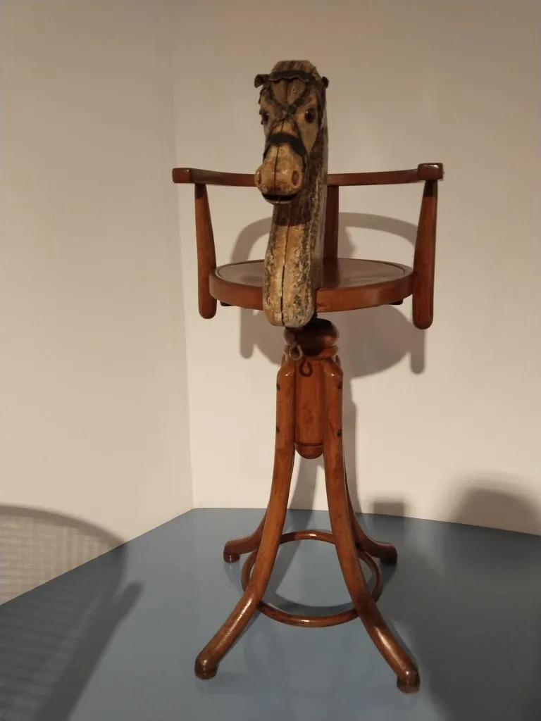 Thonet Kinderfriseurstuhl Nr. 649 B mit einem hölzernen geschnitzten Pferdekopf an der Rückenlehne, Bugholzbeinen und rundem Sitz.