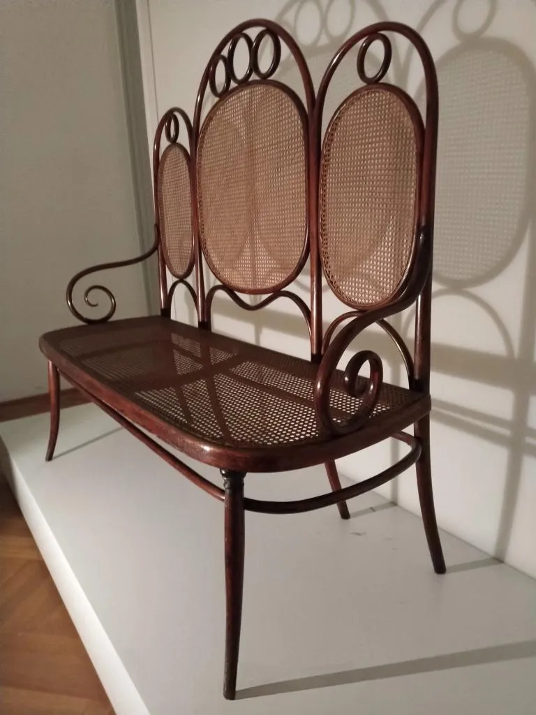 Seitenansicht des Thonet Kanapees Modell Nr. 17 mit ovalen Rohrgeflechtflächen und geschwungenem Holzrahmen.