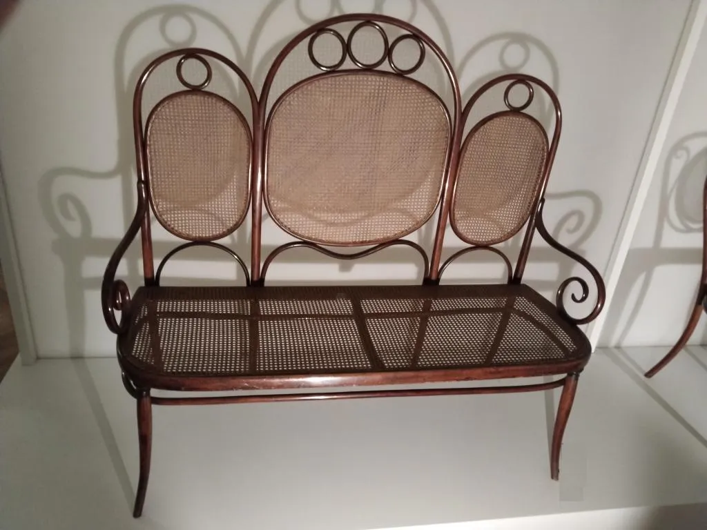 Fotografie des Thonet Bugholz-Kanapees Modell Nr. 17 mit drei ovalen Rückenteilen aus Rohrgeflecht, Sitzfläche aus Rohrgeflecht und geschwungenen Armlehnen, gefertigt von den Gebrüdern Thonet um 1880–1890.