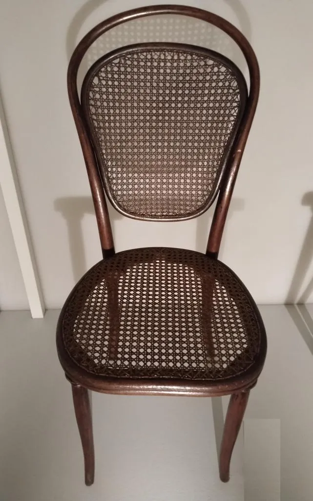 Thonet Stuhl Modell Nr. 12 aus massiv und mehrteilig gebogenem Buchenholz mit dreiteiligem Rückenlehneinsatz, geschlitzten Hinterbeinen und Rohrgeflecht an Sitz und Rückenlehne, palisanderlasiert, Entwurf Gebrüder Thonet um 1856, Ausführung Gebrüder Thonet um 1861.