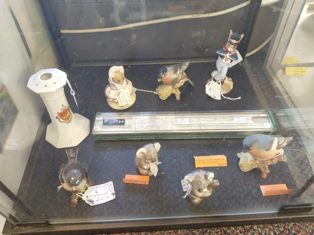 Vintage log-log slide rule displayed with animal figurines and curios.